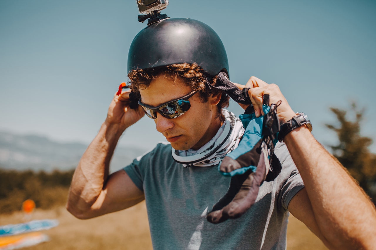 A paraglider prepares a helmet